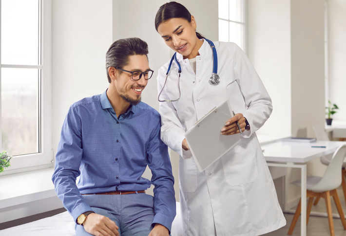 Doctor showing medical information on a clipboard to patient during consultation